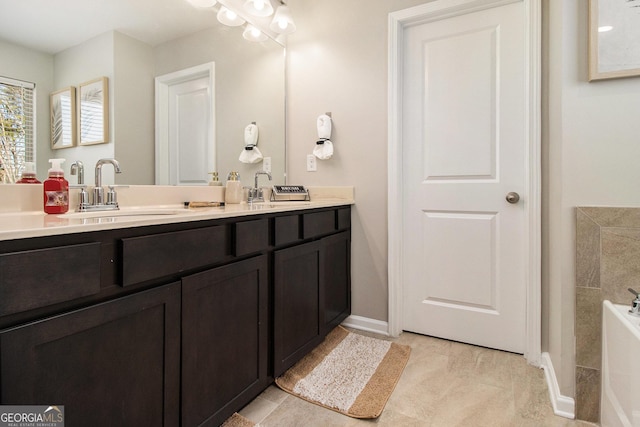 bathroom with tile patterned floors, a tub to relax in, and vanity