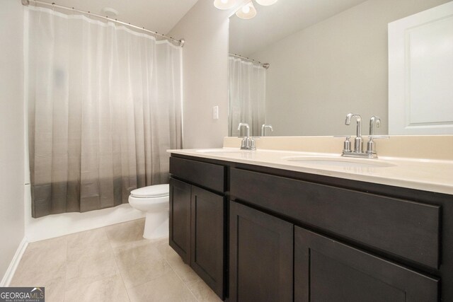 bathroom with tile patterned flooring, vanity, and toilet