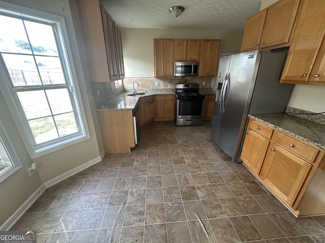 kitchen featuring decorative backsplash, sink, stainless steel appliances, and plenty of natural light