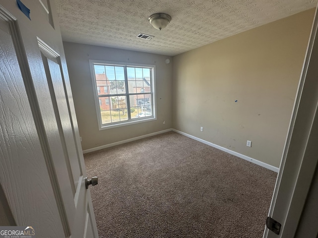 carpeted spare room featuring a textured ceiling