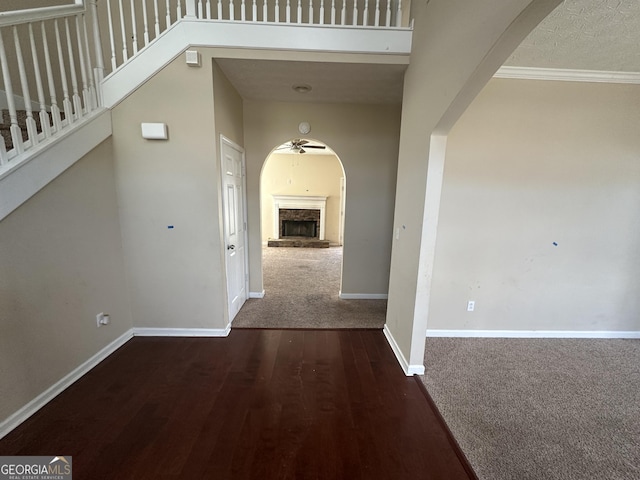 hall with dark wood-type flooring and ornamental molding