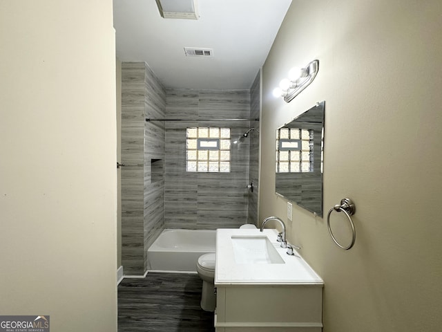 full bathroom featuring toilet, vanity, hardwood / wood-style floors, and tiled shower / bath