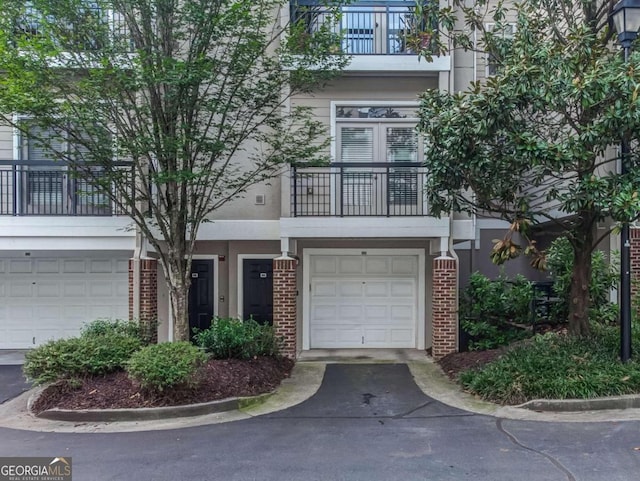 4248 River Green Dr NW Unit 312, Atlanta, GA 30327 - view of front of property featuring a balcony, brick siding, and an attached garage