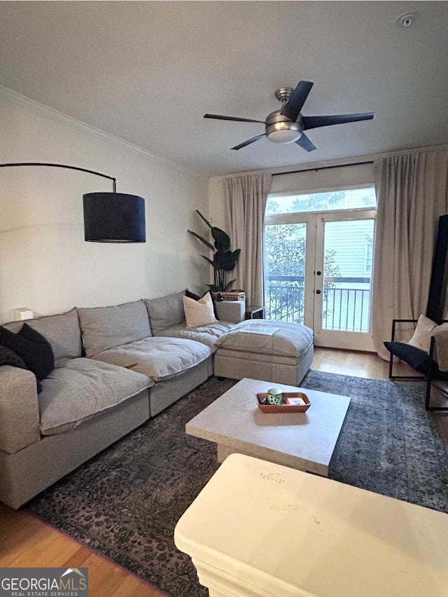 living room featuring ceiling fan, wood-type flooring, crown molding, and french doors