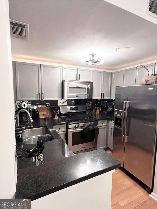 4248 River Green Dr NW Unit 312, Atlanta, GA 30327 - kitchen featuring stainless steel appliances, a sink, dark countertops, light wood finished floors, and gray cabinets