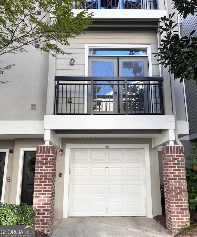 4248 River Green Dr NW Unit 312, Atlanta, GA 30327 - view of front facade with a balcony, a garage, and stucco siding