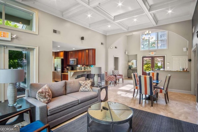 living room featuring a towering ceiling, plenty of natural light, and ornamental molding