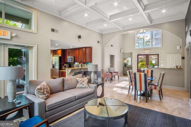 4248 River Green Dr NW Unit 312, Atlanta, GA 30327 - living area featuring a chandelier, a towering ceiling, coffered ceiling, beam ceiling, and baseboards