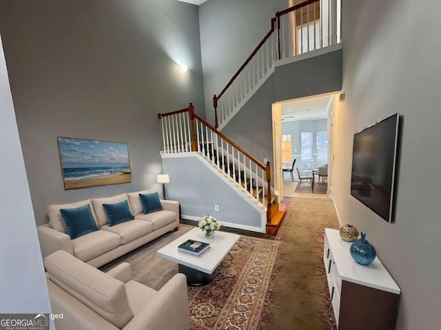 carpeted living room featuring a towering ceiling