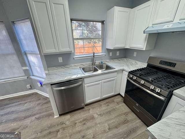 kitchen featuring white cabinets, sink, stainless steel appliances, and light hardwood / wood-style flooring