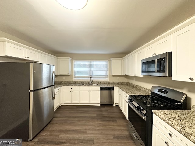 kitchen featuring white cabinets, sink, dark hardwood / wood-style floors, light stone countertops, and stainless steel appliances