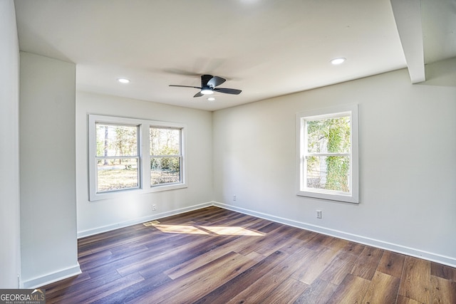 empty room with ceiling fan and dark wood-type flooring