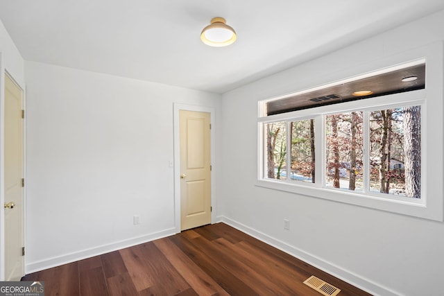 spare room with dark hardwood / wood-style flooring