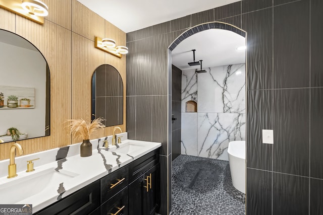 bathroom with a bathtub, vanity, and tile walls