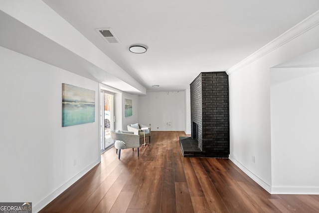 living room with a fireplace, dark wood-type flooring, and ornamental molding