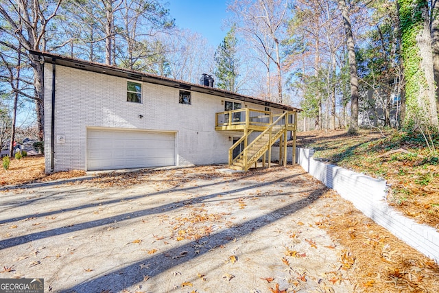 back of property with a garage and a wooden deck