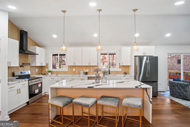 kitchen featuring stainless steel appliances, dark wood-type flooring, wall chimney range hood, white cabinets, and a kitchen island