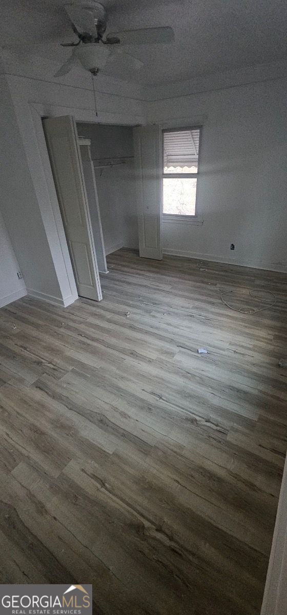 spare room with wood-type flooring and ceiling fan