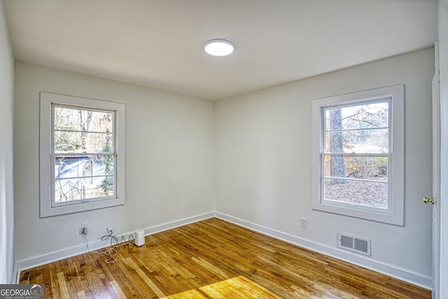 unfurnished room featuring hardwood / wood-style flooring