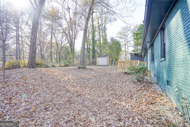 view of yard featuring a shed and a wooden deck