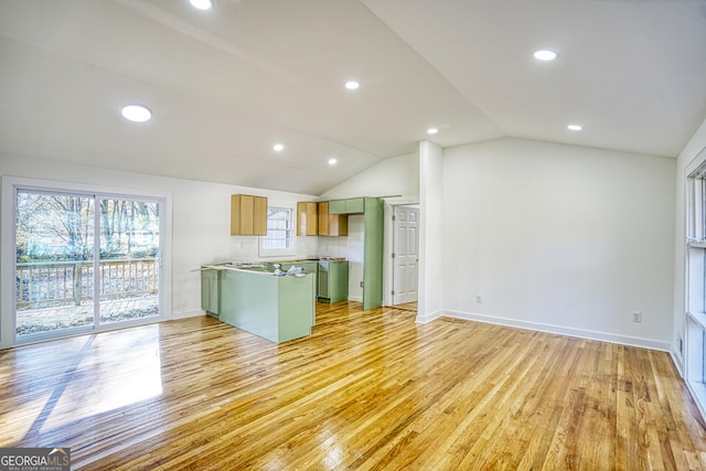 kitchen with decorative backsplash, kitchen peninsula, light hardwood / wood-style flooring, lofted ceiling, and green cabinets