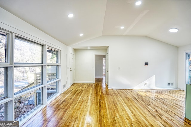 interior space with light hardwood / wood-style floors and vaulted ceiling