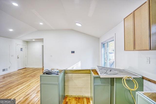 kitchen featuring vaulted ceiling, light wood-type flooring, and green cabinetry