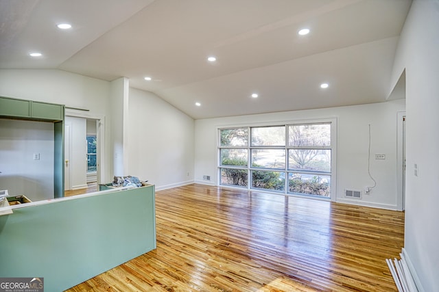 unfurnished living room with light wood-type flooring and vaulted ceiling