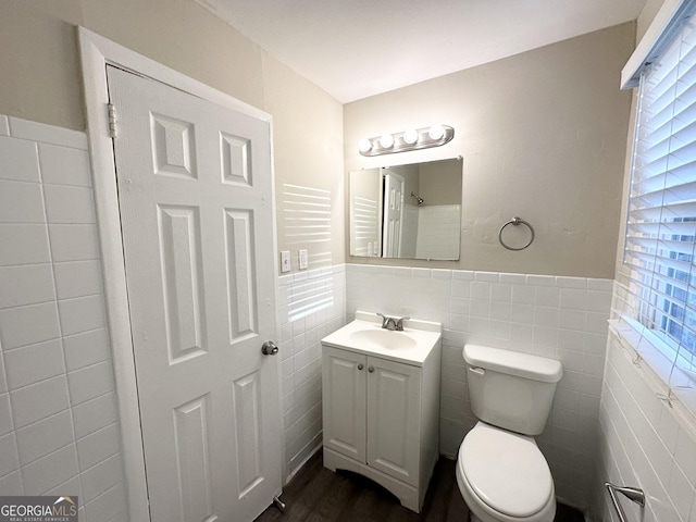 bathroom with vanity, tile walls, and toilet