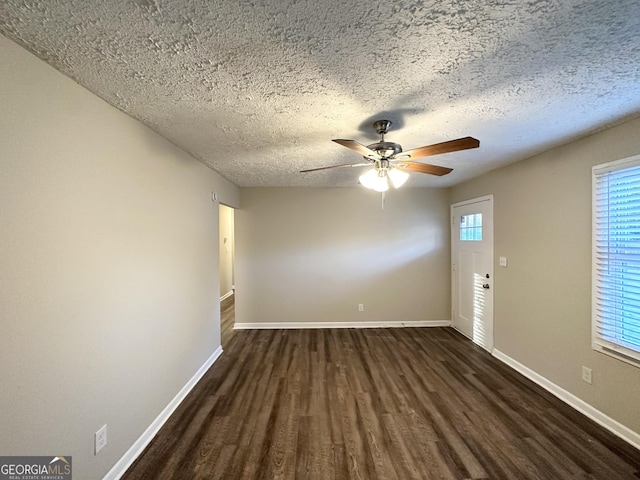 spare room with ceiling fan, dark wood-type flooring, and a textured ceiling