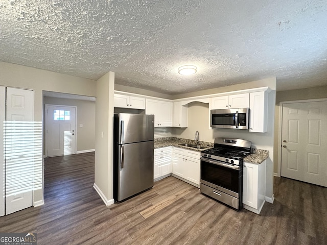 kitchen with dark hardwood / wood-style flooring, stainless steel appliances, white cabinetry, and sink