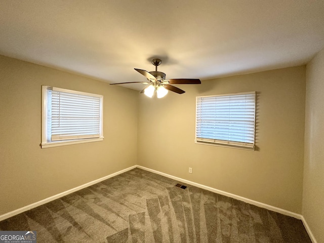 spare room featuring carpet, a wealth of natural light, and ceiling fan