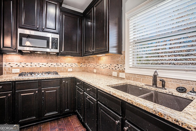 kitchen with sink, dark wood-type flooring, light stone counters, backsplash, and appliances with stainless steel finishes