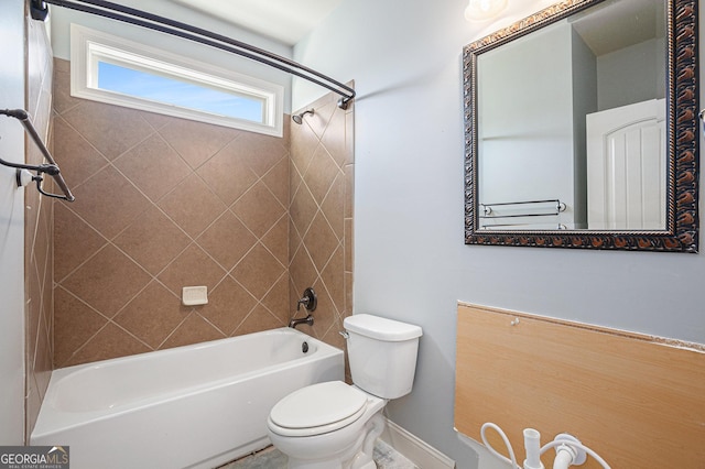 bathroom featuring toilet and tiled shower / bath