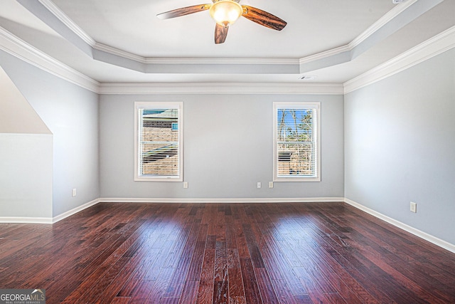 unfurnished room with dark hardwood / wood-style flooring, a tray ceiling, ceiling fan, and ornamental molding