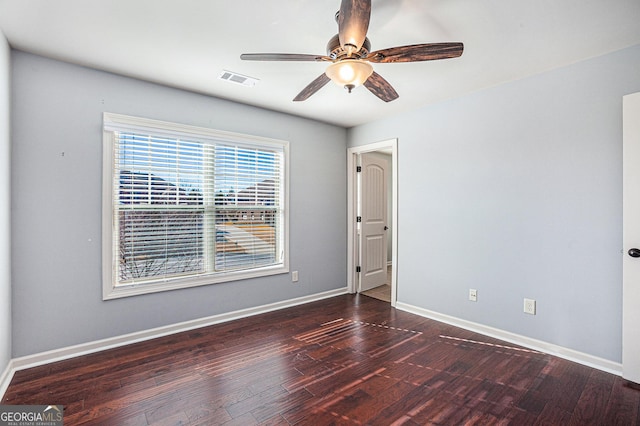 empty room featuring ceiling fan and dark wood-type flooring