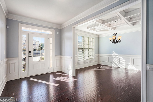 entrance foyer with a notable chandelier, beamed ceiling, coffered ceiling, and ornamental molding