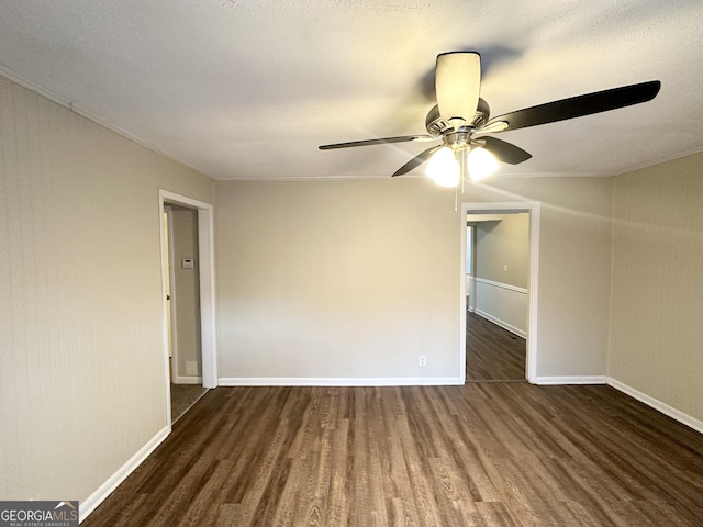 spare room featuring ceiling fan, dark hardwood / wood-style flooring, and crown molding