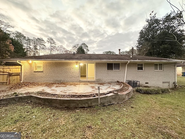 rear view of property with central AC and a yard