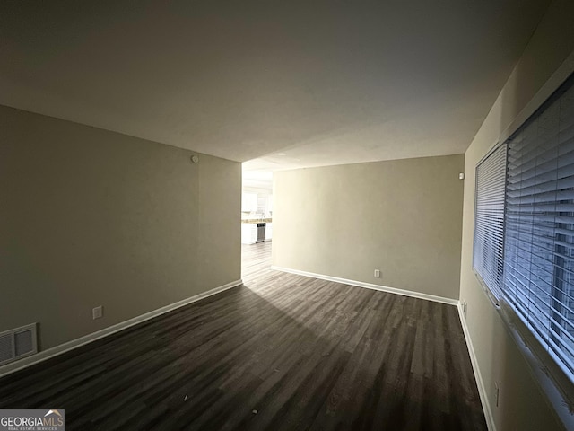 unfurnished room featuring dark wood-type flooring