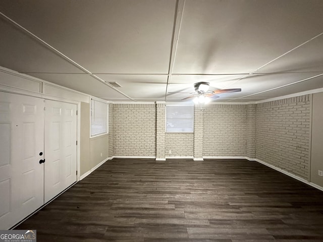 interior space featuring dark wood-type flooring and brick wall