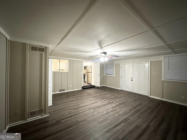 unfurnished bedroom with dark hardwood / wood-style flooring, stainless steel refrigerator, and ceiling fan