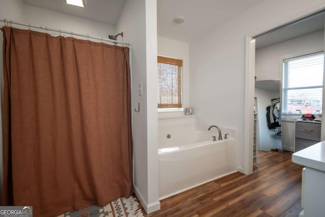 bathroom featuring plus walk in shower, wood-type flooring, and vanity