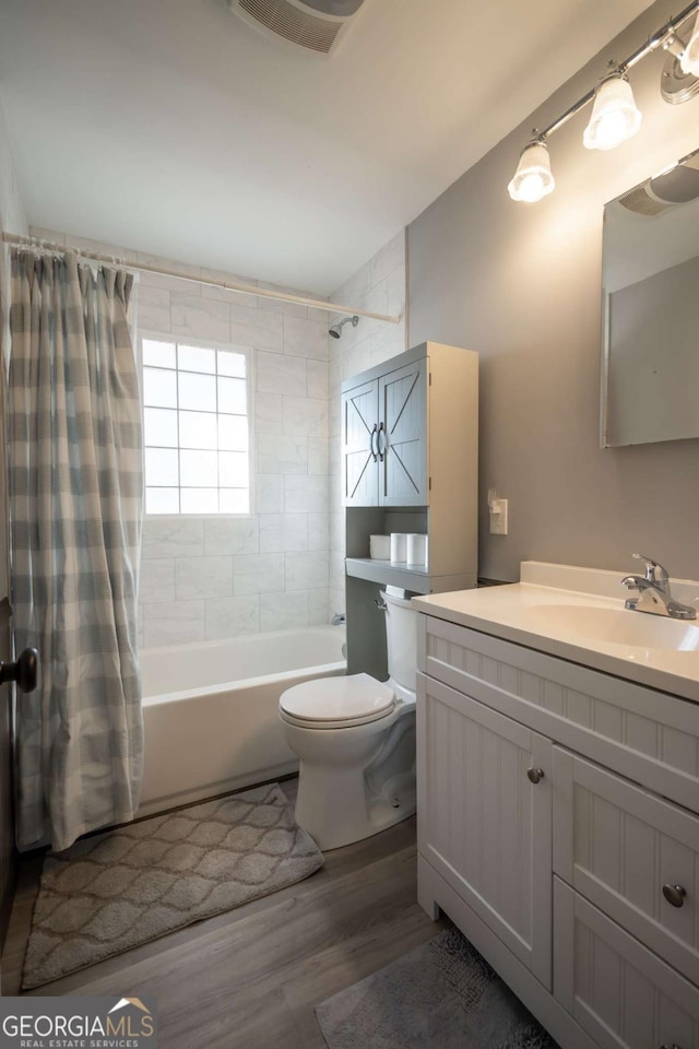 full bathroom featuring toilet, shower / tub combo with curtain, vanity, and hardwood / wood-style flooring