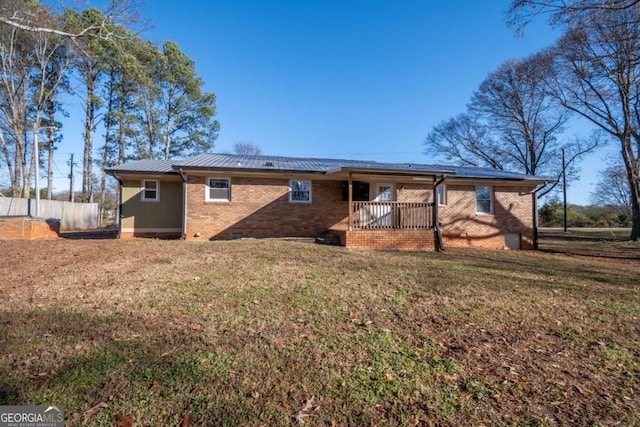 back of house featuring a lawn and a wooden deck