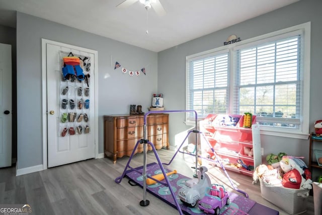 recreation room with ceiling fan, a healthy amount of sunlight, and wood-type flooring