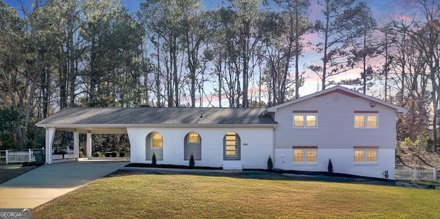 view of front of house with a carport and a lawn