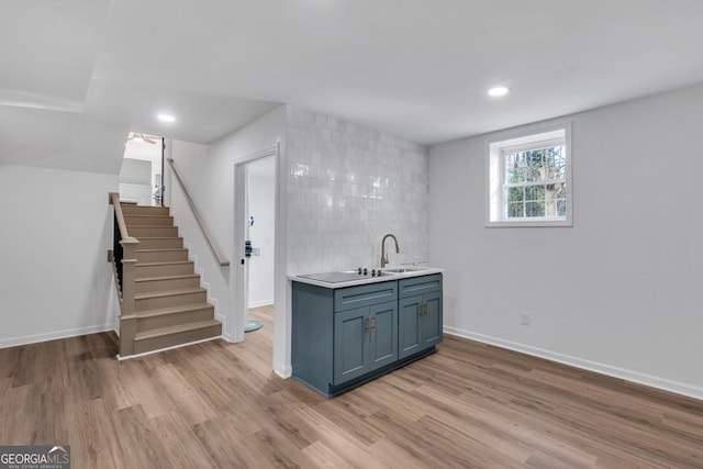 kitchen featuring tasteful backsplash, sink, and light hardwood / wood-style floors