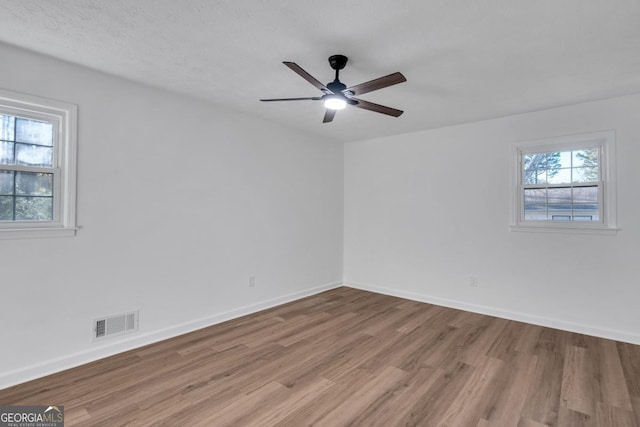 unfurnished room with ceiling fan, a textured ceiling, and light hardwood / wood-style flooring