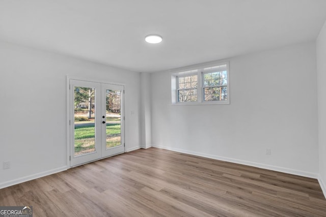 empty room featuring light wood-type flooring and french doors